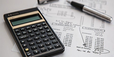 Calculator on a table with financial information.