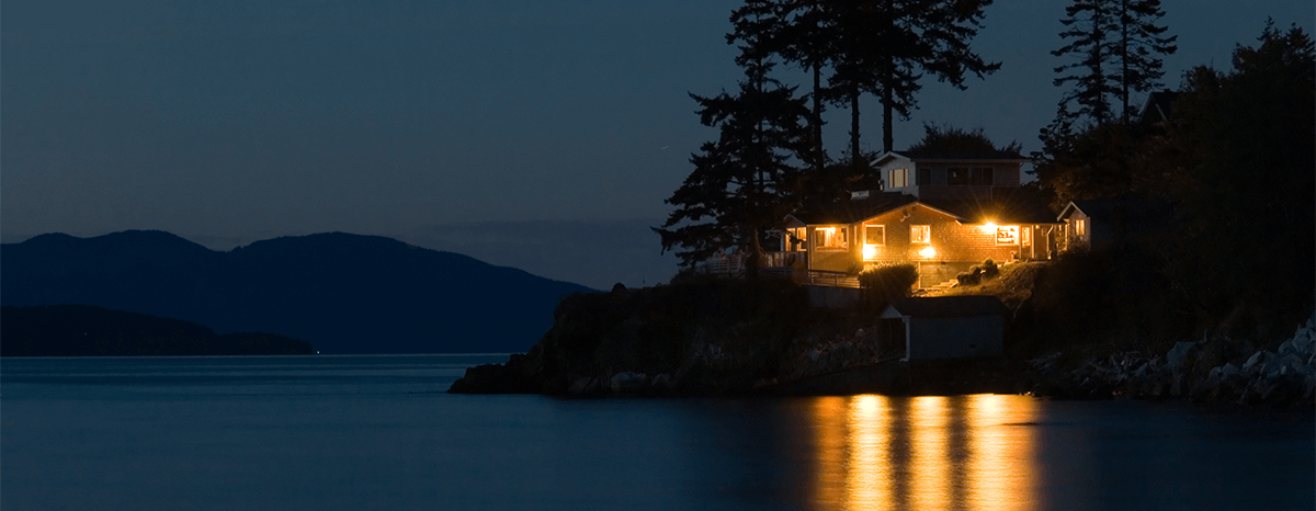 Lake house on the right at night with all the lights on.