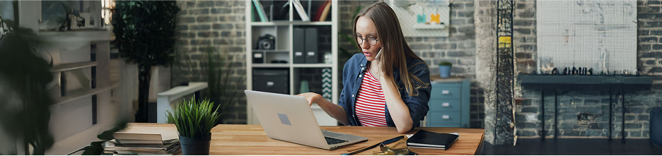 Woman on the phone with a laptop, filing hurricane insurance claims as part of the recovery process